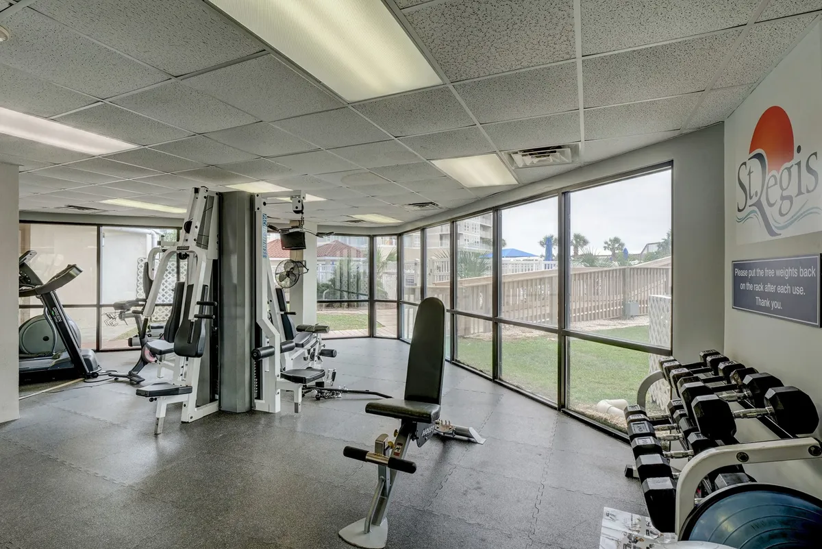 A bright, modern fitness center equipped with exercise machines and free weights. Large windows offer sweeping views, creating an inspiring environment for workouts, with guests engaging in personal training or group fitness activities.
